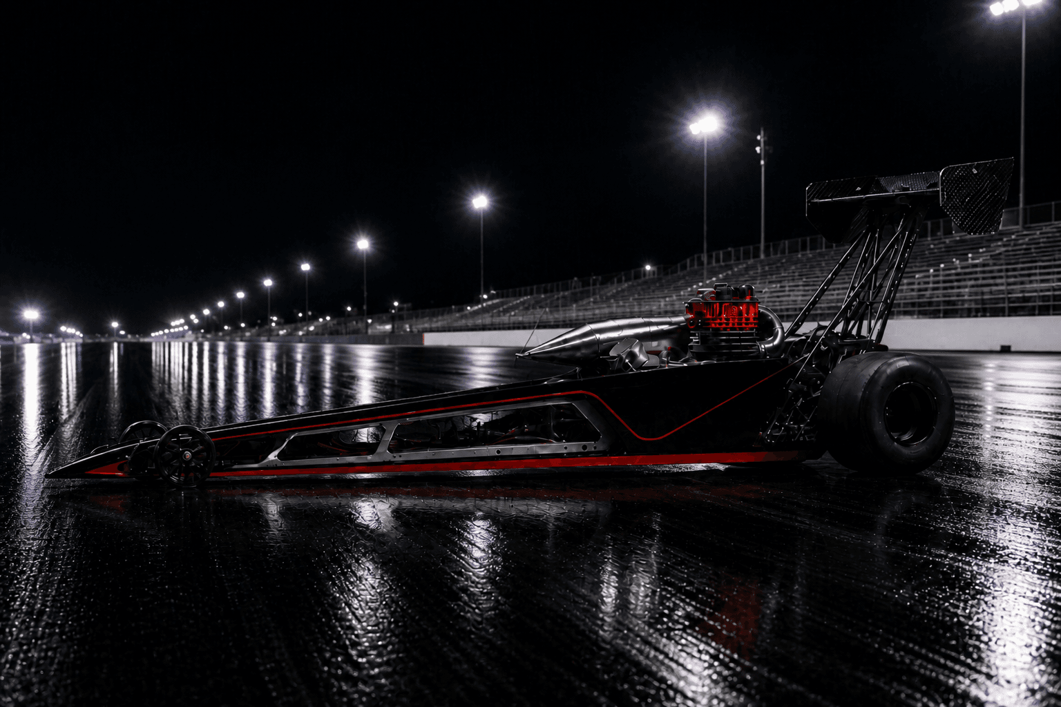 Large-scale gas RC dragster with gloss black SRE body shell and red engine on a night drag strip